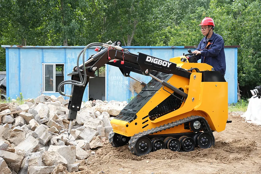 A DIG-BOY stand on skid steer loader with tracks, offering superior traction on delicate surfaces